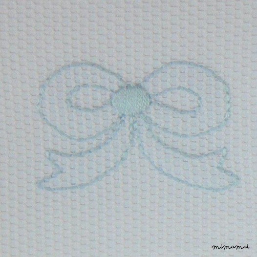Copertina lettino in piqu&eacute; di cotone ricamata a mano con nodo d'amore a punto erba